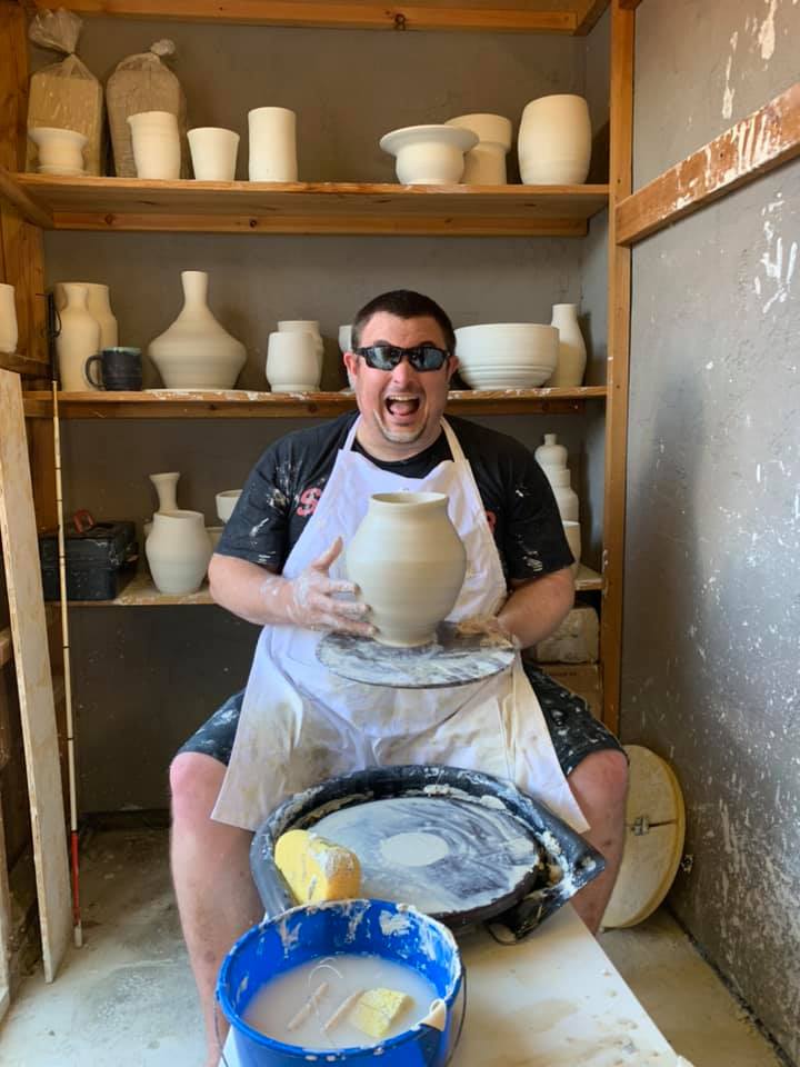 A picture of Kelvin Crosby holding a ceramic vase