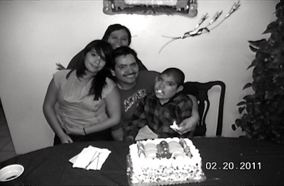 Myrna, Deloris, Juan y Norman frente a una torta cubierta de crema.