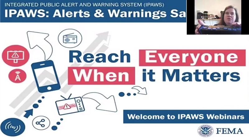 Presentation slide. Title: Integrated Public Alert and warning system (IPAWS). Over the slide, on the top right, image of Megan Dausch showing a braille display.