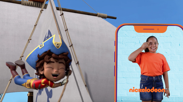 Cartoon of a pirate boy. On the right, on a mobile phone screen, a girl does sign language. In orange letters the word Nickelodeon appears at the bottom of the phone screen.
