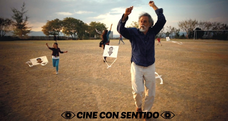 Manuel Toledo runs with kites. Behind him, children follow