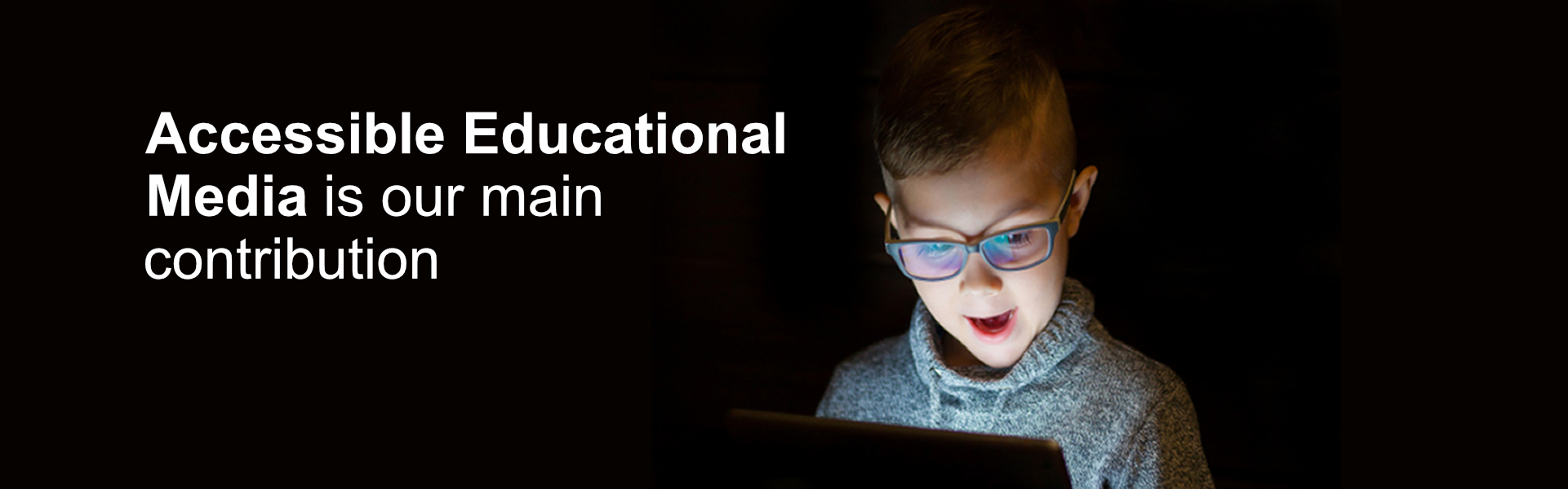 Accessible Educational Media is our main contribution. Background image: a kid looks at a tablet with awe. 