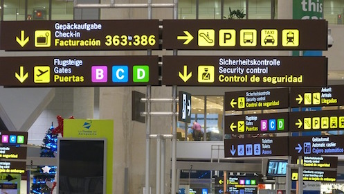 Airport signs with several icons and arrows pointing to different directions