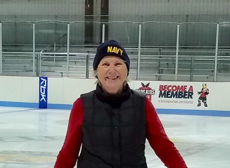 A woman in winter gear in an ice skating ring