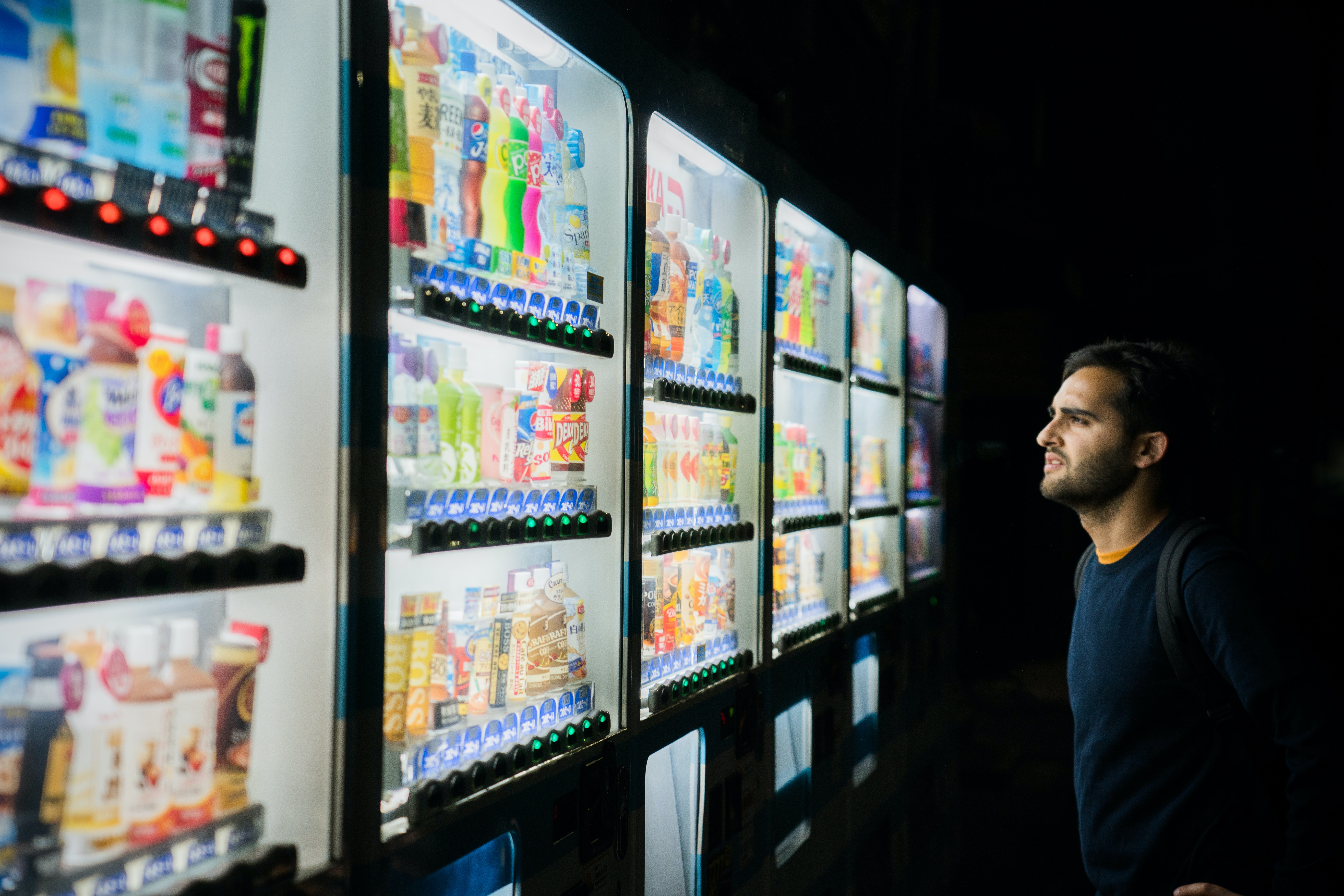 a man looking at sodas in a supermarket