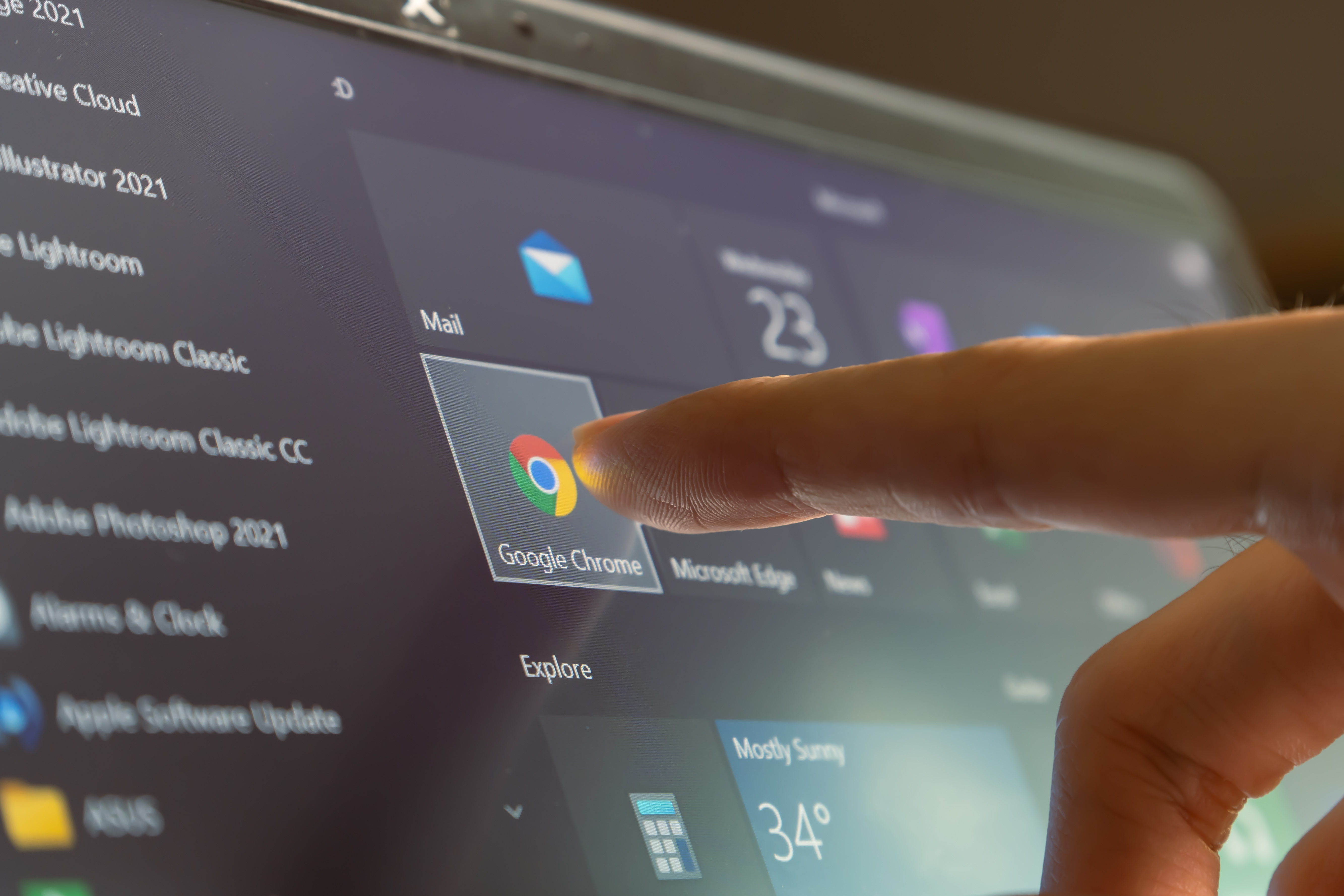 a person touching the google chorme logo on a touch display